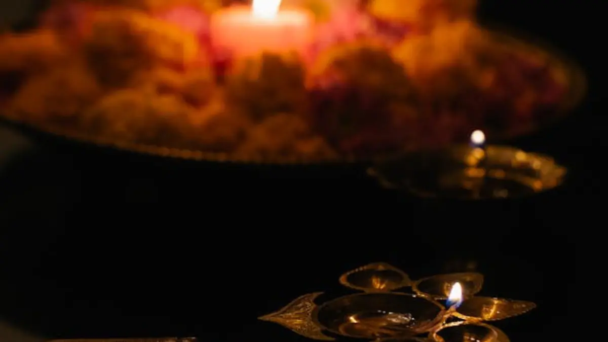 A single diya oil lamp burning in the dark, representing spiritual observance for the Masya dates in 2025.