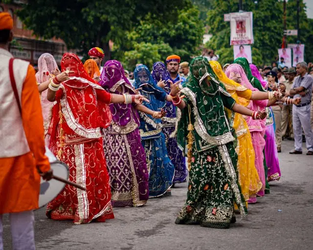 Women in colorful traditional dresses dance in a circle to celebrate a spring festival like Basant Panchami.