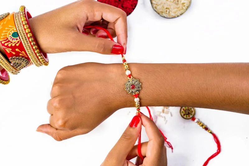 A sister tying rakhi on brother’s wrist on Raksha Bandhan – part of Hindu festivals 2025